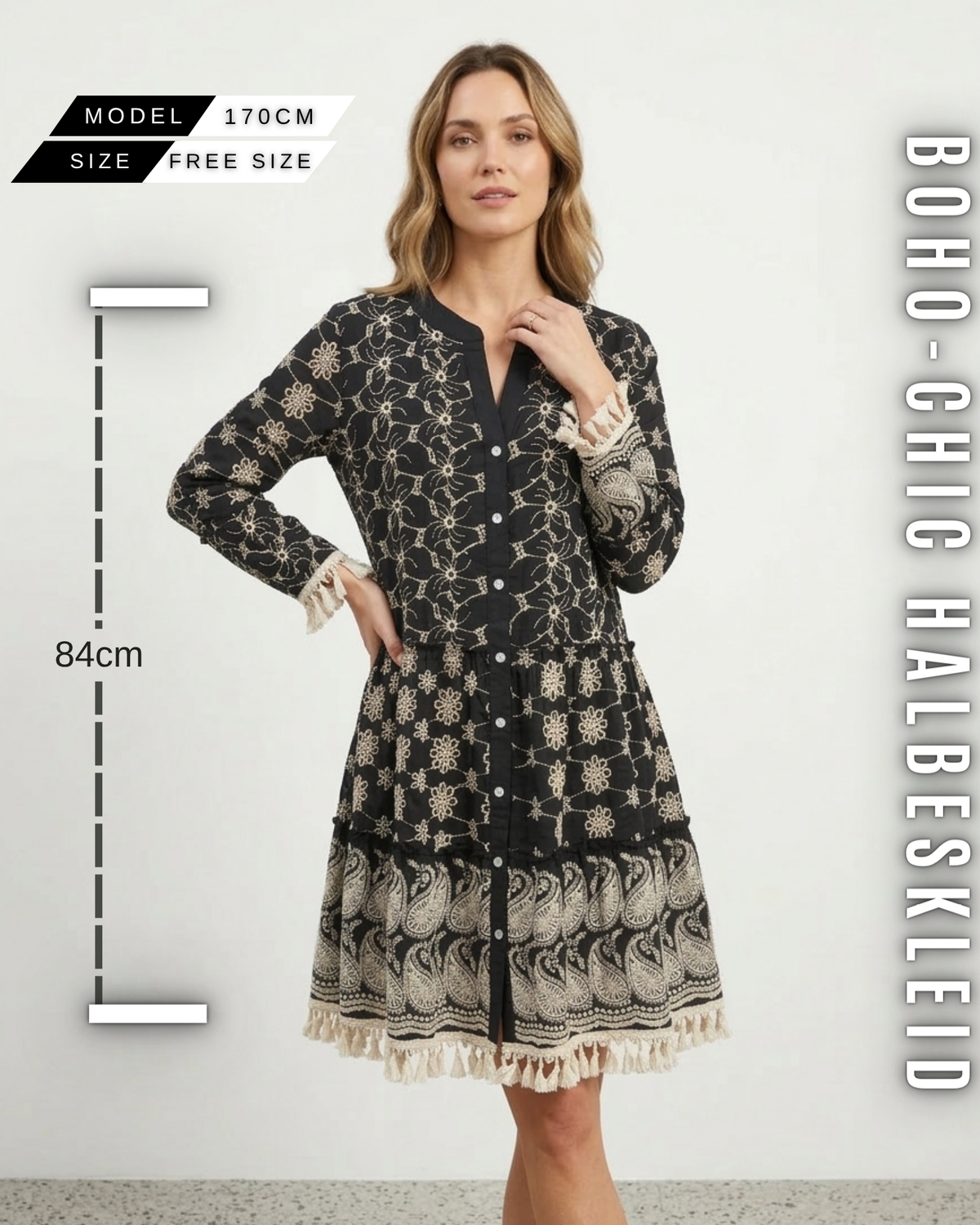 Schwarzes Boho-Minikleid vor weißem Hintergrund, Frontansicht mit Maßen (Länge 84cm, Free Size, Model 170cm), cremefarbener Lochstickerei und Fransensaum.