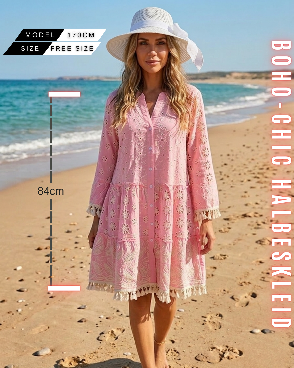 Frontansicht einer Frau an einem sonnigen Strand in einem rosafarbenen Boho-Mini-Kleid mit weißem Sonnenhut, aufwendiger Stickerei und Quastenfransen. Abmessungsgrafiken zeigen Free Size, 84 cm Länge für eine Körpergröße von 170 cm. Text 'BOHO-CHIC HALBESKLEID'.