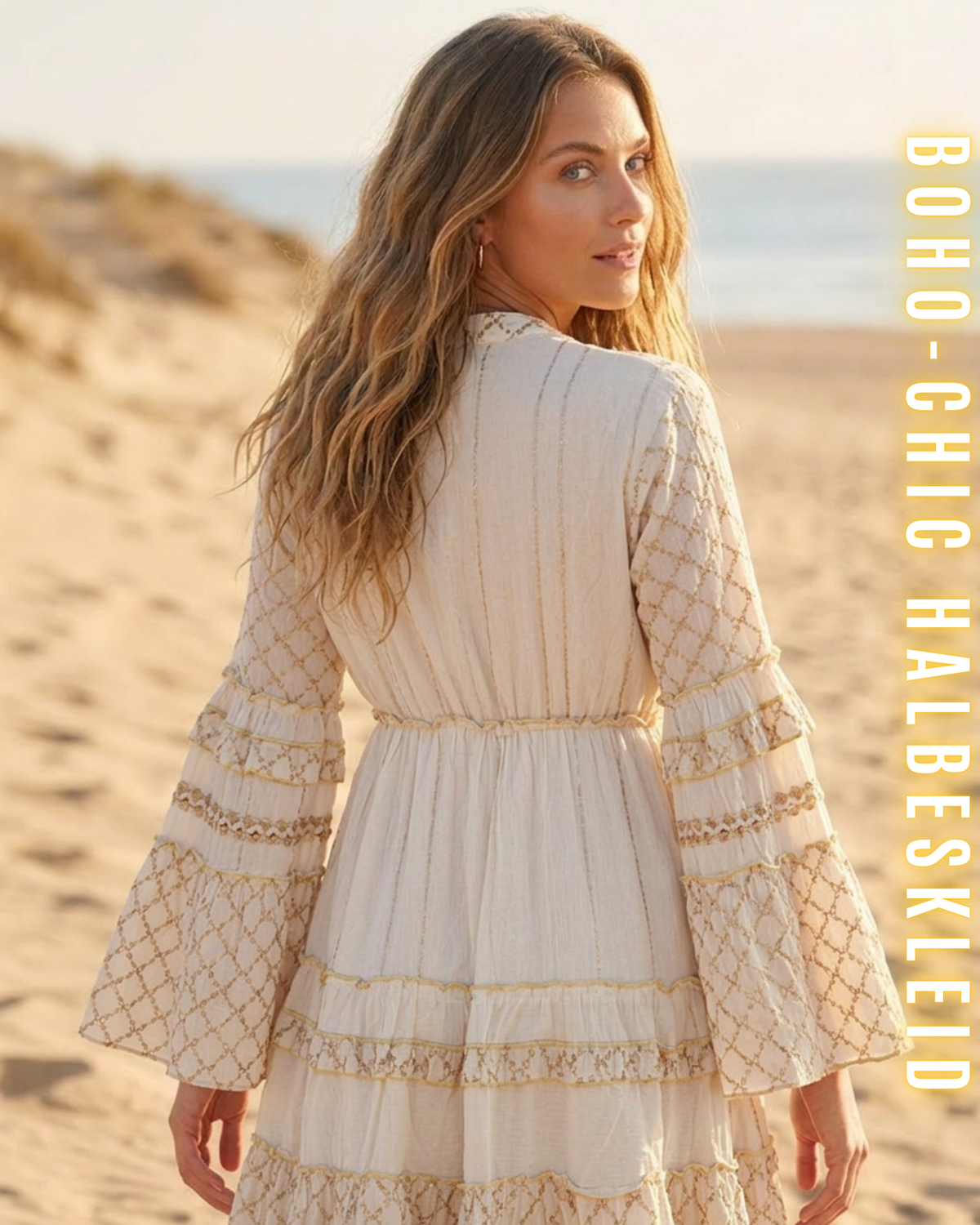 Nahaufnahme der Rückseite eines weißen Boho-Chic-Halbkleides am Strand, die detaillierte goldene Stickerei und die gestuften Glockenärmel zeigt. Frau blickt über die Schulter zurück. Vertikaler Text: BOHO-CHIC HALBESKLEID.