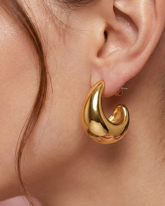 Detailansicht des massiven goldenen Ohrrings am Ohr.