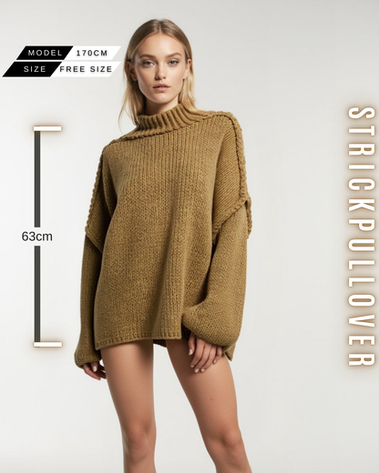 Eine Frau in einem kamellbraunen, grob gestrickten Pullover mit Stehkragen, weiten Ärmeln und mit Größe Information.