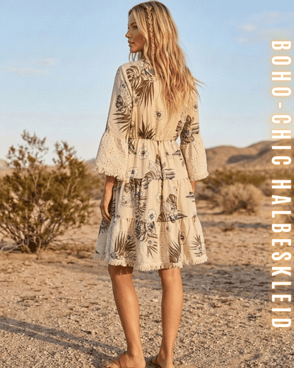 Rückansicht des beigen Boho-Sommerkleids mit floralem Print, elastischer Taille und Fransen-Saum.