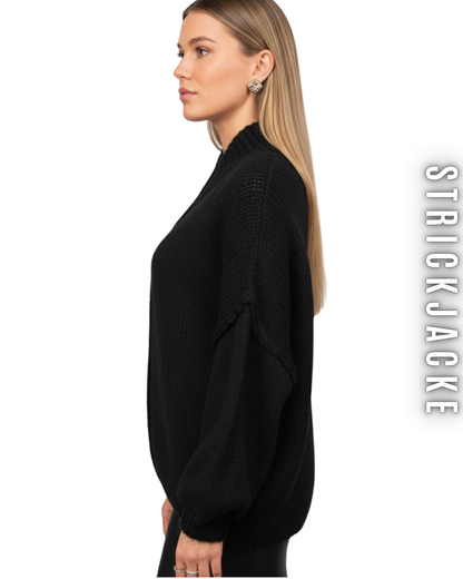 Seitenansicht einer Frau in einem schwarzen, hochgeschlossenen Strickcardigan mit Oversize-Ärmeln.