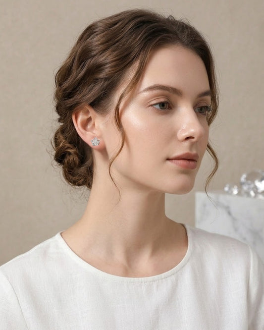 Seitenprofil einer Frau mit elegant hochgestecktem Haar, die den zierlichen, silberfarbenen Blüten-Ohrstecker am Ohr trägt.