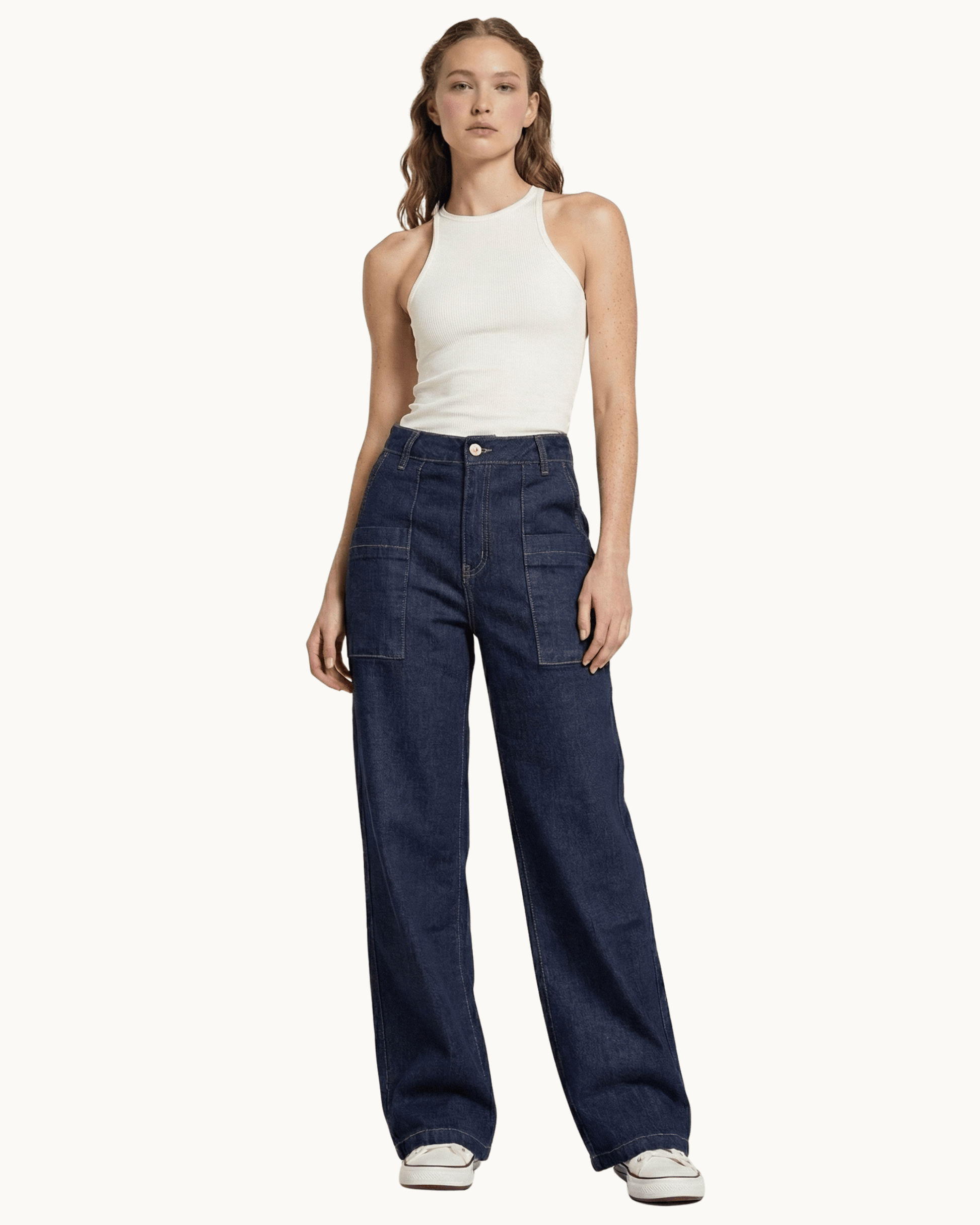 Ganzkörperansicht eines Models in dunkelblauer Wide Leg Utility Jeans und weißem Top.