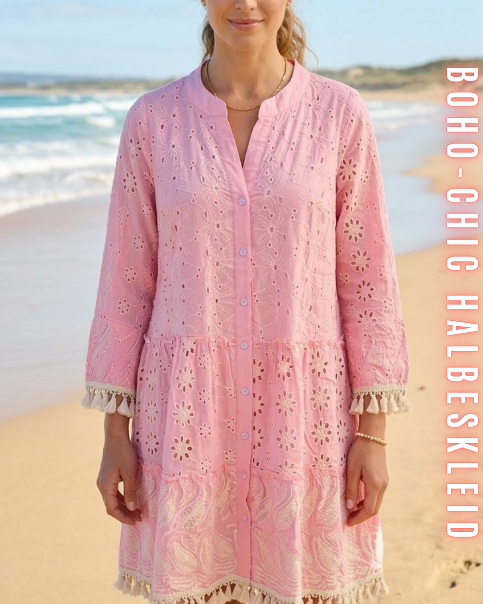 Nahaufnahme der Frontansicht eines rosafarbenen Boho-Chic-Mini-Kleides, das die aufwendige Stickerei mit Paisley- und Sternenmotiven, die Knopfleiste und die Quastenfransen-Details an den Ärmelbündchen zeigt, vor einem Strandhintergrund. Beinhaltet den Text 'BOHO-CHIC HALBESKLEID'.