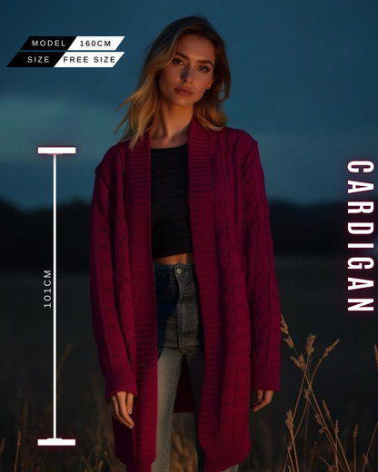 Eine Frau in einem langen, bordeauxroten Strick-Cardigan mit Zopfmuster.