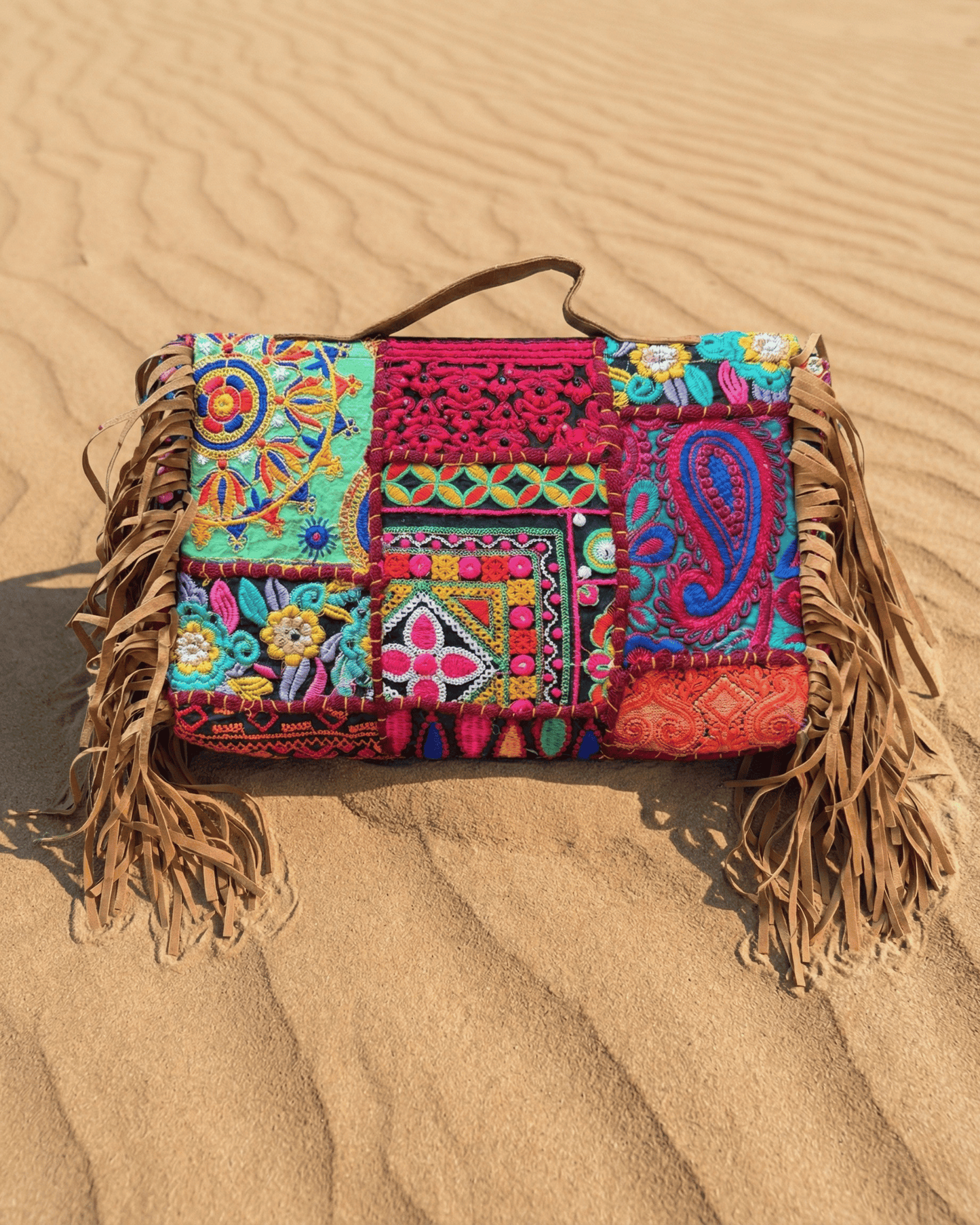 Nahaufnahme der großflächigen Handstickerei und der metallischen Verzierungen am oberen Rand.