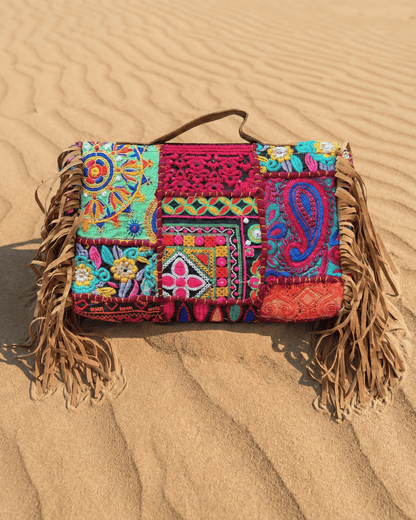 Nahaufnahme der großflächigen Handstickerei und der metallischen Verzierungen am oberen Rand.