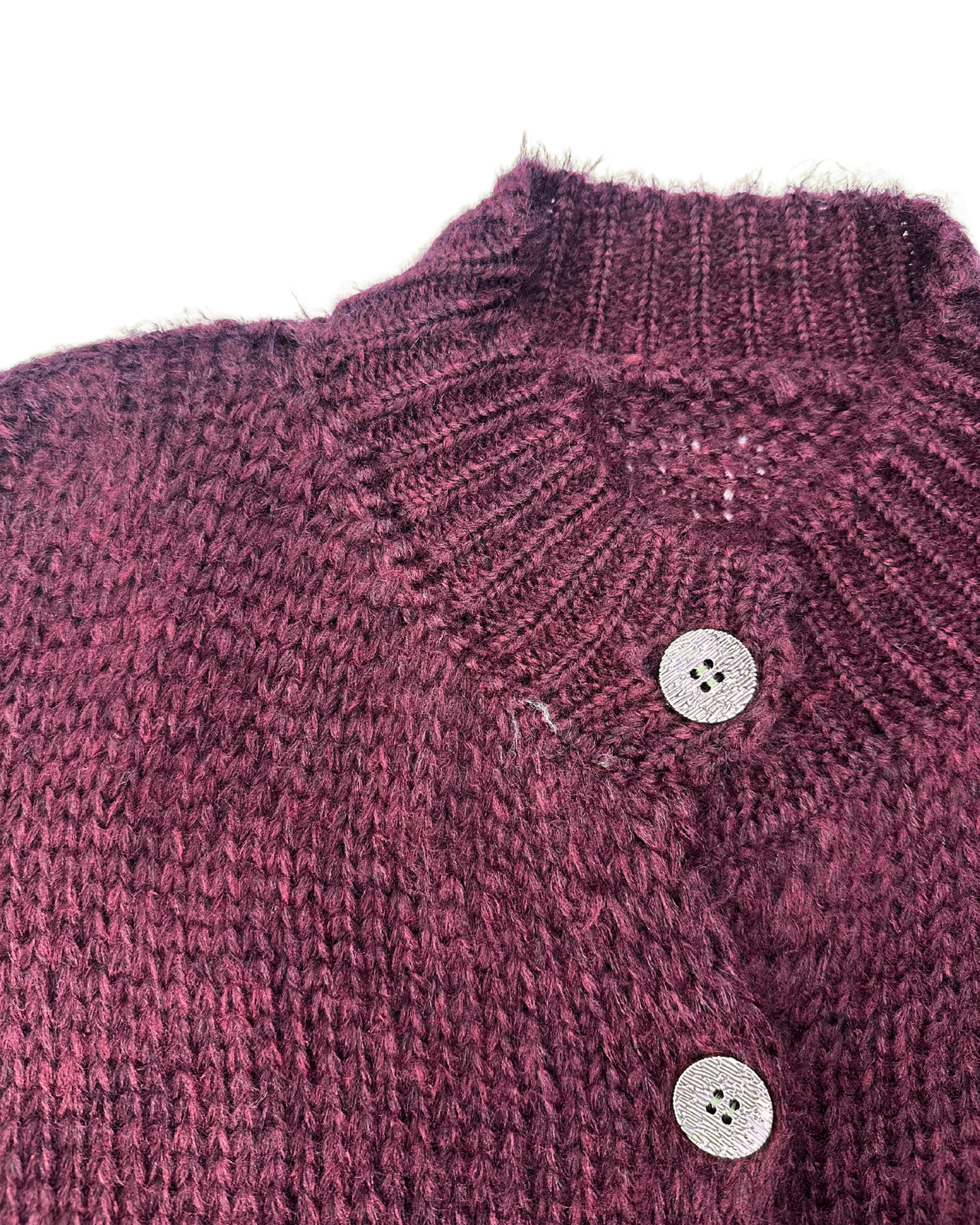 Nahaufnahme des weinroten, gerippten Kragens und der glänzenden Knöpfe des Cardigans.