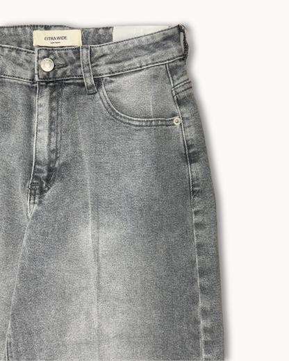 Detailaufnahme des Hosenbundes der grauen Jeans mit „Extra Wide“ Label und silbernem Knopf.