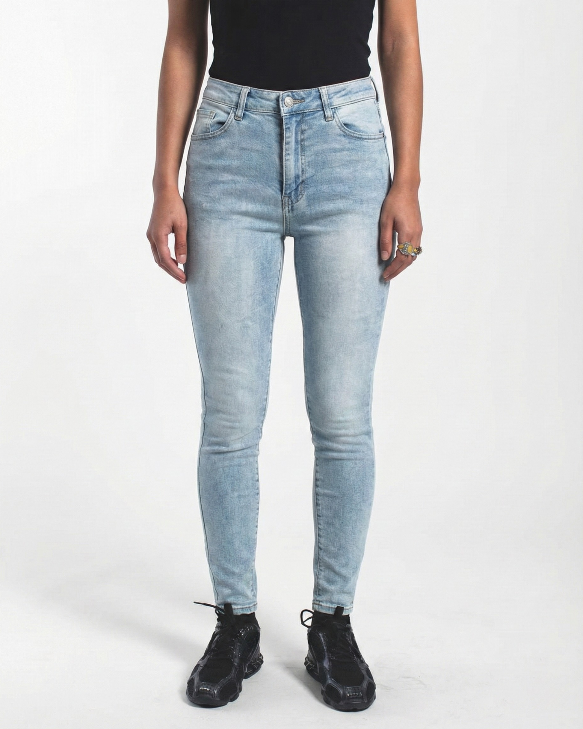 Frontansicht einer Frau in hellblauer High Waist Skinny Jeans mit schwarzem Top.