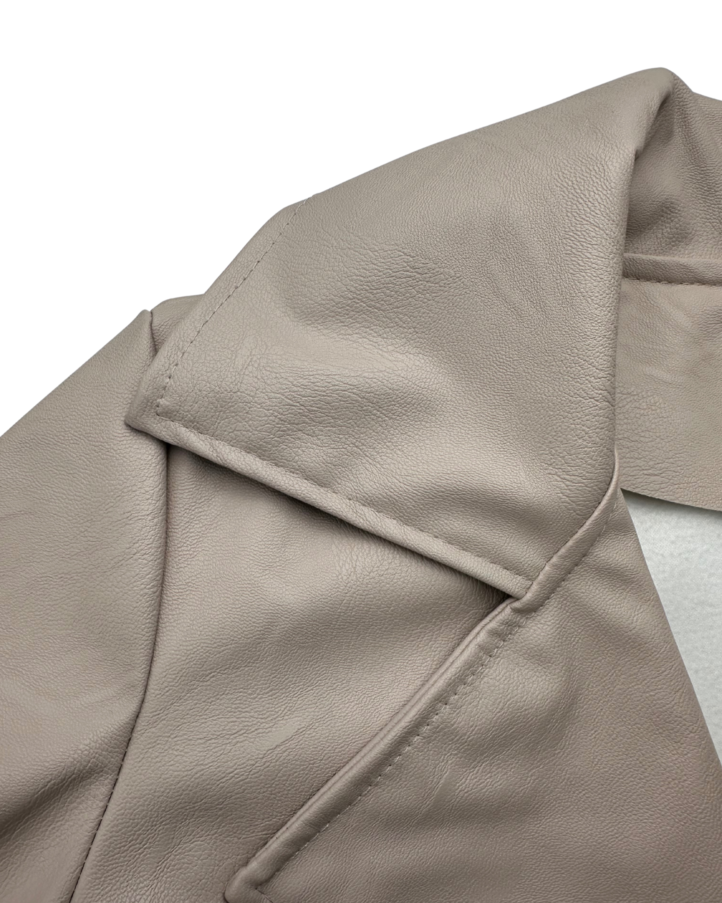 Nahaufnahme des beigen Kunstleders, die die feine Narbung und die weiche Stoffinnenseite zeigt.