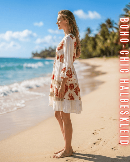 Seitliche Ansicht des Kleides mit rotfarbener Stickerei vor einer Küstenkulisse.