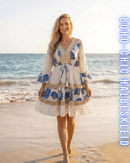 Kurzes weißes Boho-Kleid mit königsblauer Paisley-Stickerei und Fransen am Strand.