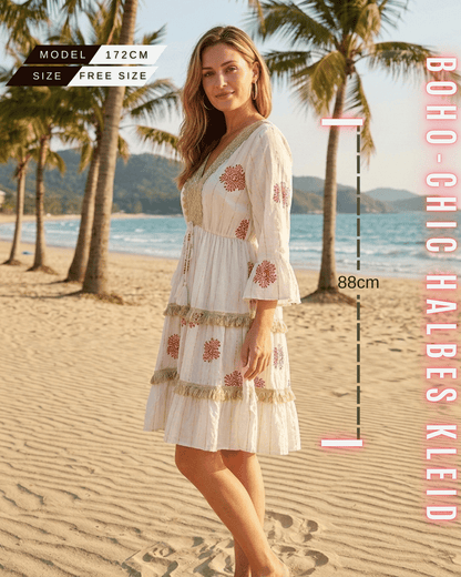 Seitliche Ansicht eines weißen Mini-Kleides mit rostroten Stickereien.