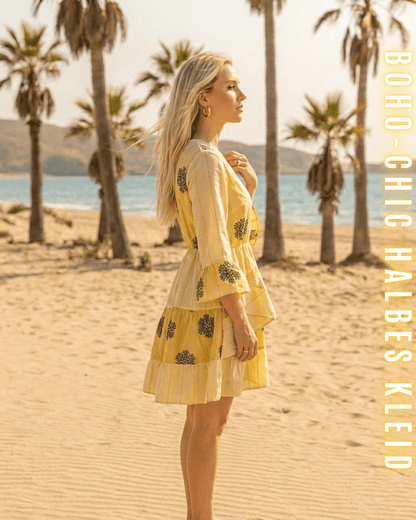 Seitliche Ansicht eines gelben Mini-Kleides mit rostroten Stickereien.