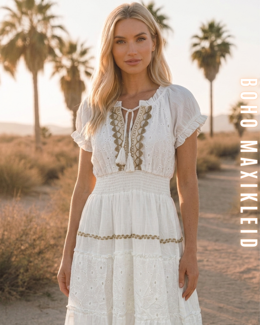 Frau im weißen Boho-Maxikleid mit Lochstickerei in einer Wüstenlandschaft.
