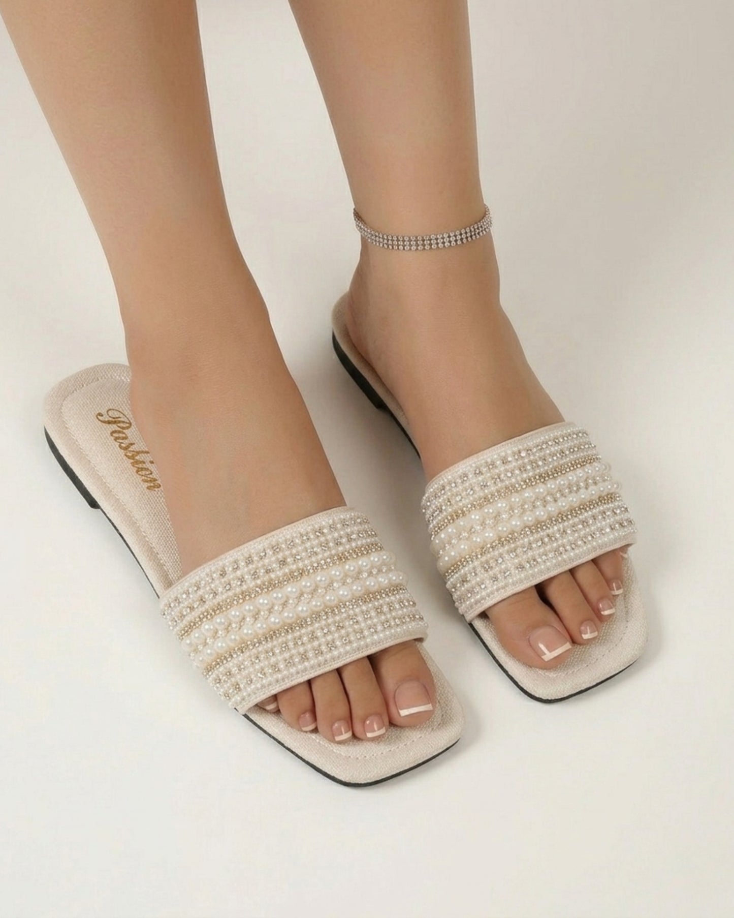 Draufsicht aus der Vogelperspektive auf die flachen Slip-On-Sandalen mit sichtbarem „Passion“-Schriftzug auf der Innensohle.