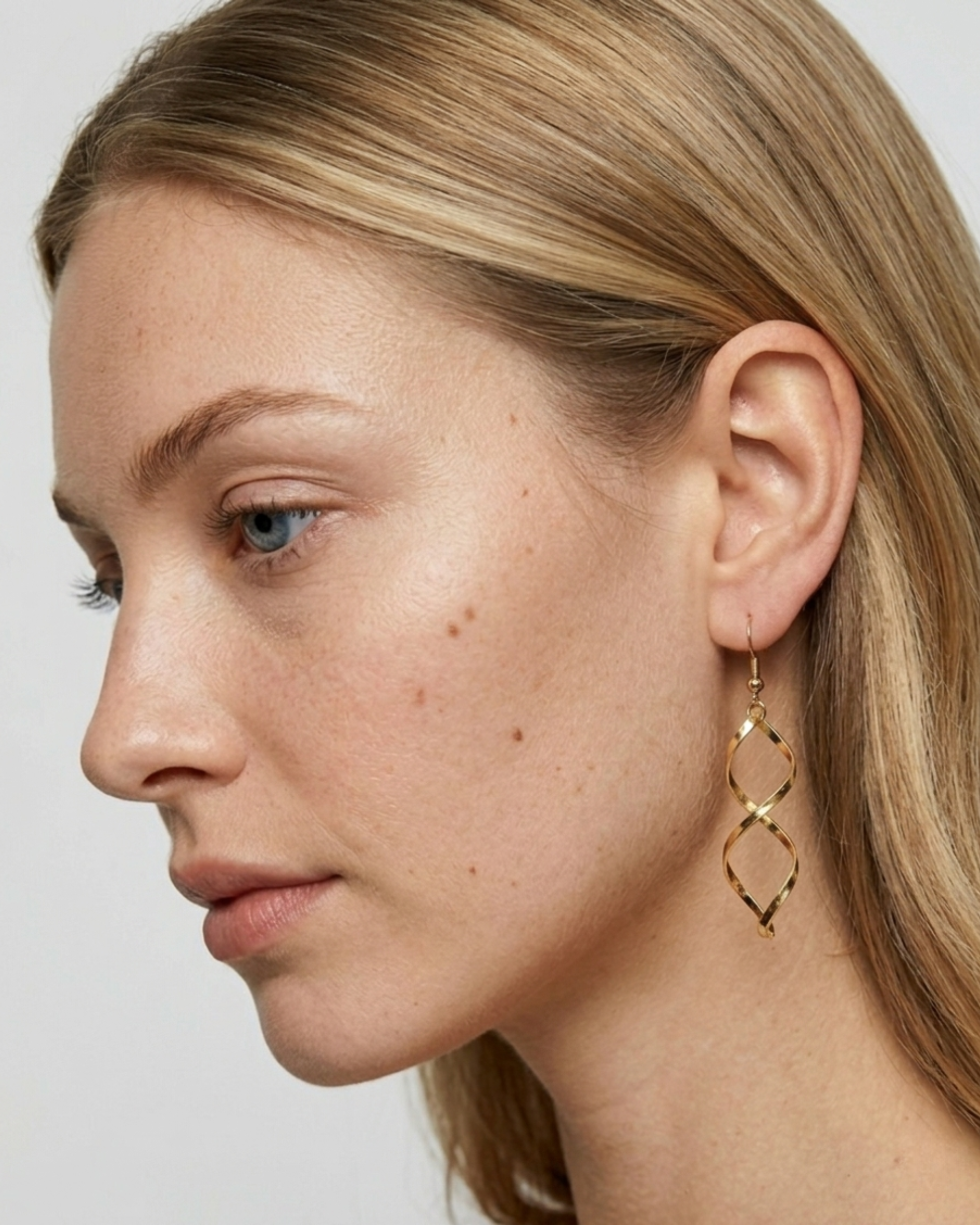 Seitenprofil eines Models mit den goldenen ELARA Doppel-Hängeohrringen.