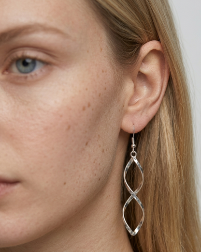 Detailansicht der silbernen Twisted Hängeohrringe am Ohr getragen.