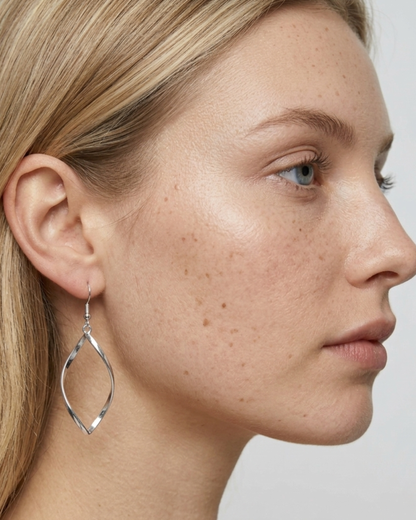 Seitenprofil-Ansicht eines Models, das einen silbernen TWIST Ohrring trägt.