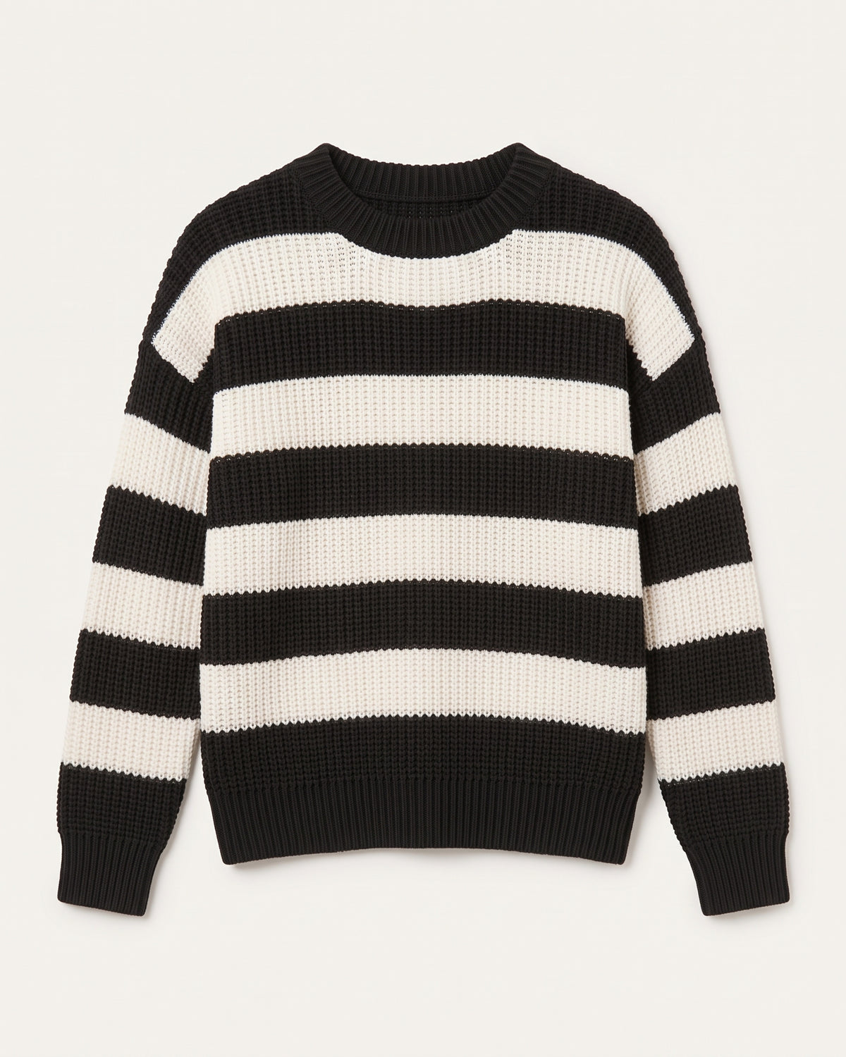 Grob gestrickter Damenpullover mit Rundhalsausschnitt und markanten, breiten Blockstreifen in Schwarz und Cremeweiß vor einem neutralen, hellen Hintergrund. Der Pullover hat überschnittene Schultern und elastische Rippbündchen an Ärmeln und Saum.