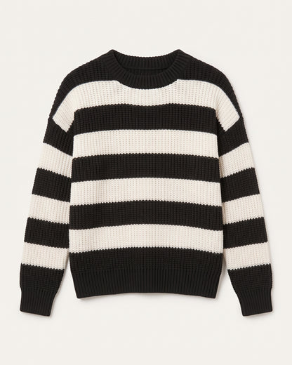 Grob gestrickter Damenpullover mit Rundhalsausschnitt und markanten, breiten Blockstreifen in Schwarz und Cremeweiß vor einem neutralen, hellen Hintergrund. Der Pullover hat überschnittene Schultern und elastische Rippbündchen an Ärmeln und Saum.