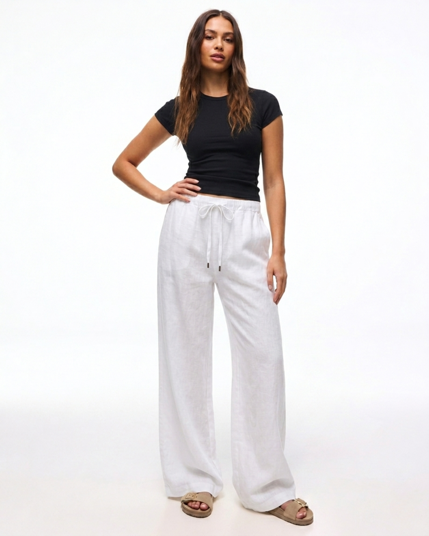 Damen trägt die weiße Leinenhose mit weitem Bein und Kordelzug.