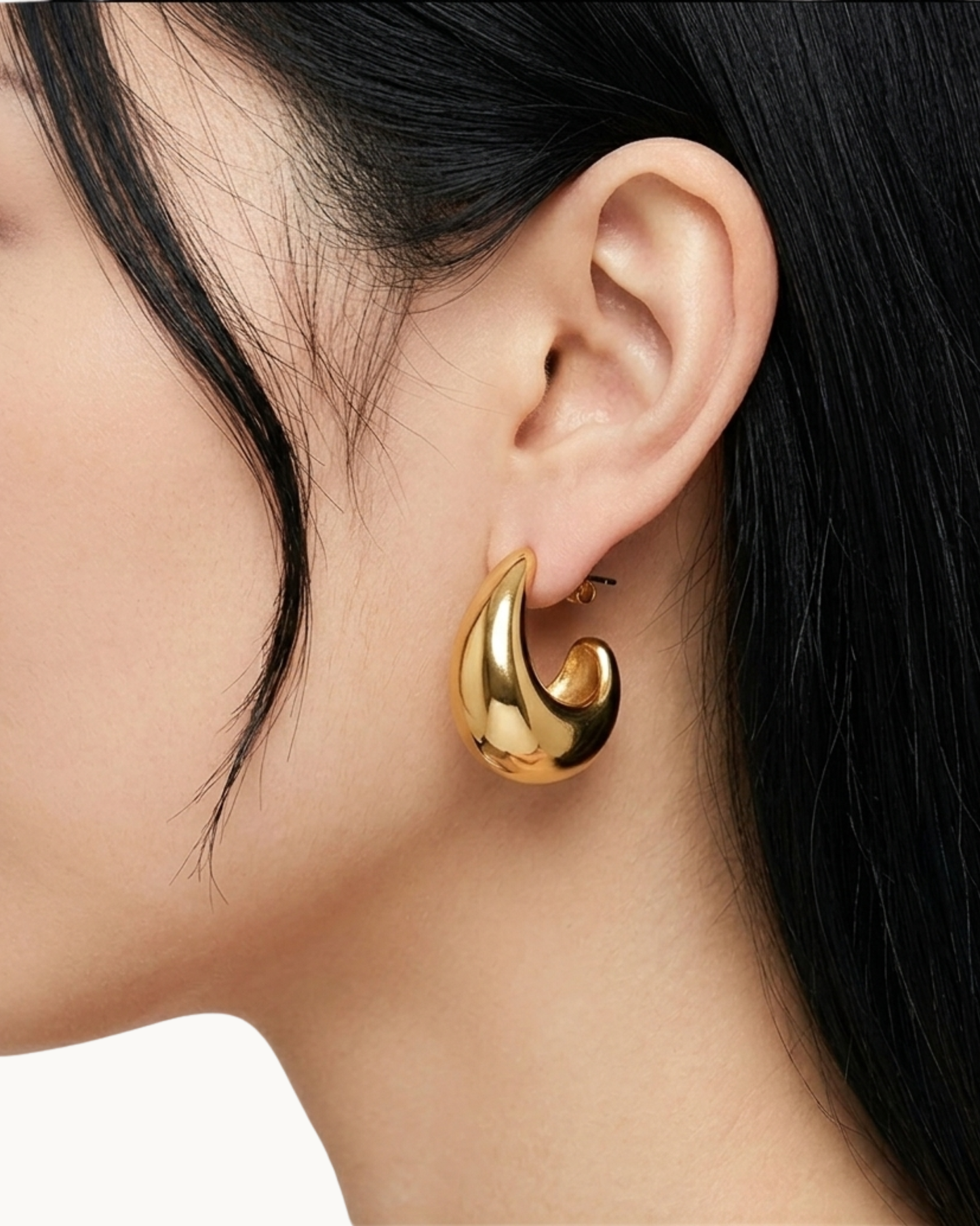 Detailansicht des massiven goldenen Ohrrings am Ohr.