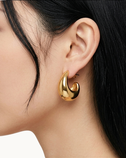 Detailansicht des massiven goldenen Ohrrings am Ohr.