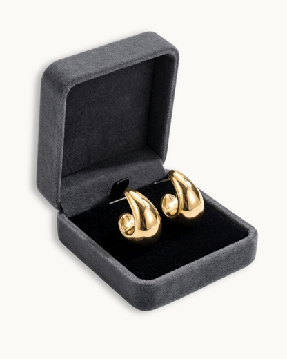 Die goldenen VALERIA Ohrringe präsentiert in einer grauen Samtbox.