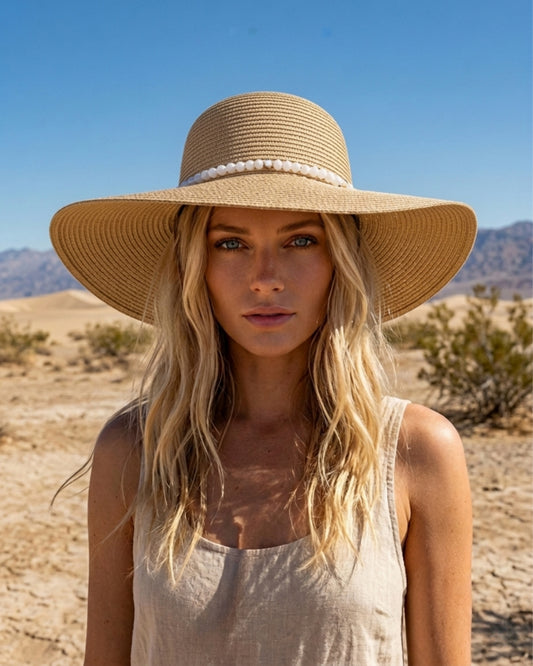 Frontalaufnahme einer Frau im hellen Top, die den geformten Sonnenhut „Milos“ mit breiter Krempe trägt.