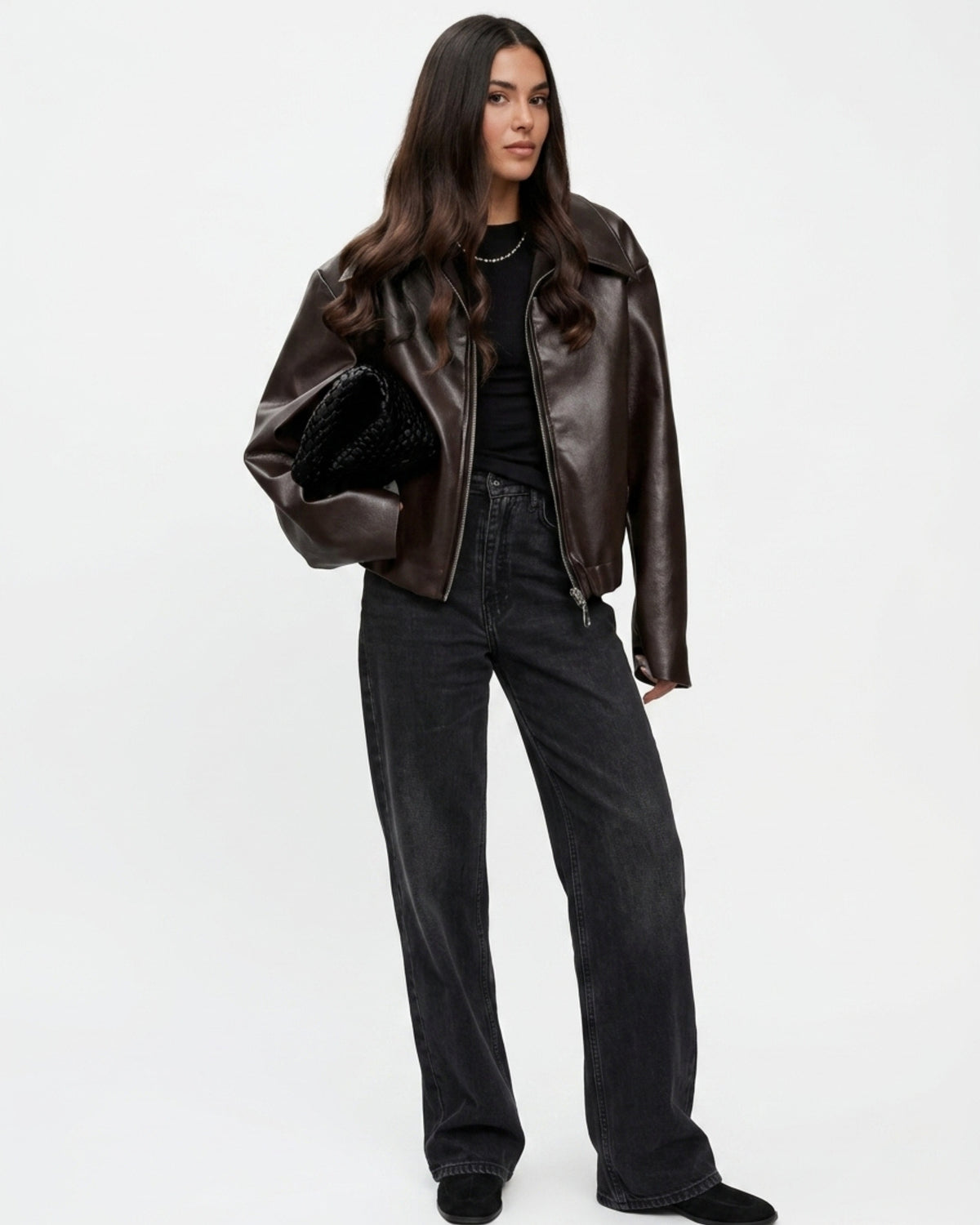 Streetwear Outfit: Weite braune Lederjacke kombiniert mit weiter schwarzer Jeans und Tasche